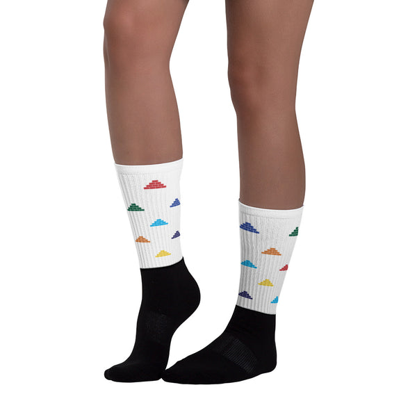 Woman wearing white and black socks with multi color build daily brick by brick logo