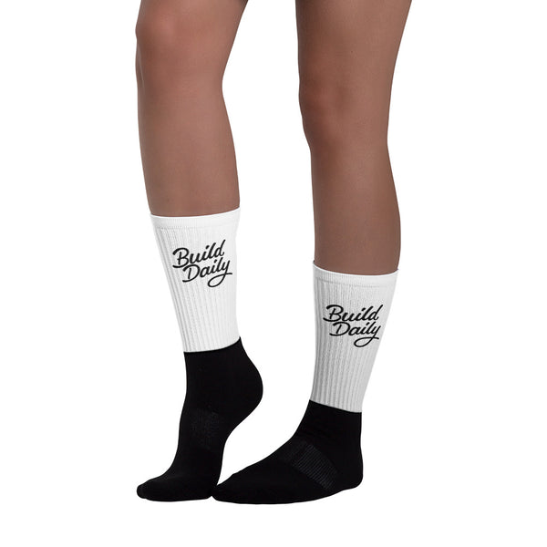 Woman wearing white and black socks with black build daily signature logo