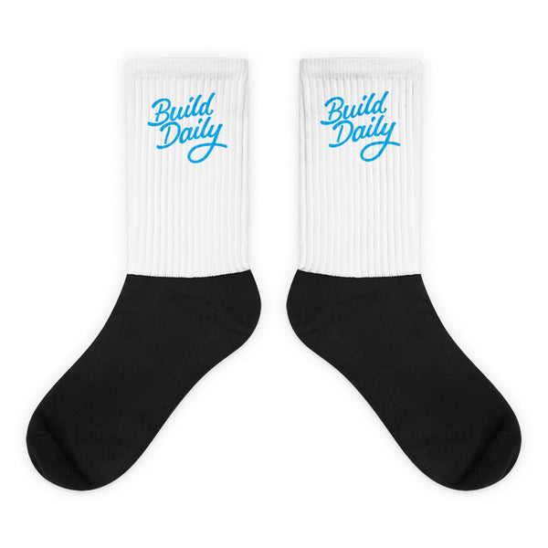 White and black socks with light blue build daily signature logo