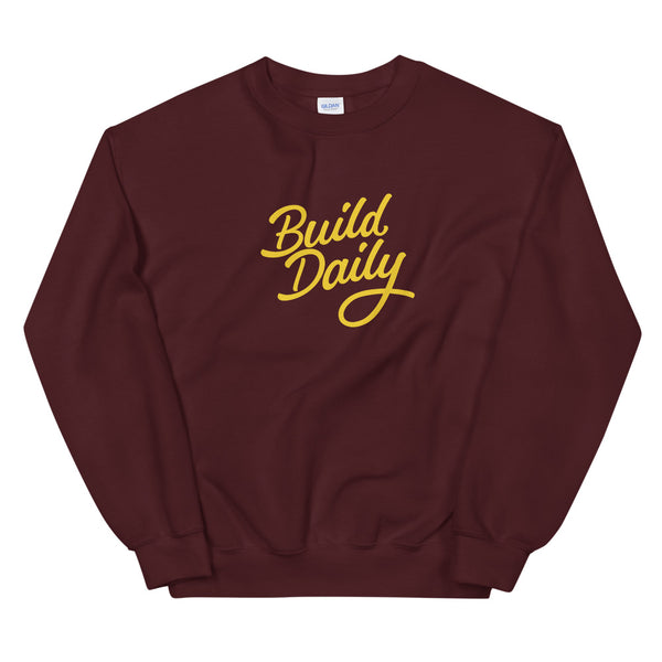 Maroon crewneck sweatshirt with yellow build daily signature logo