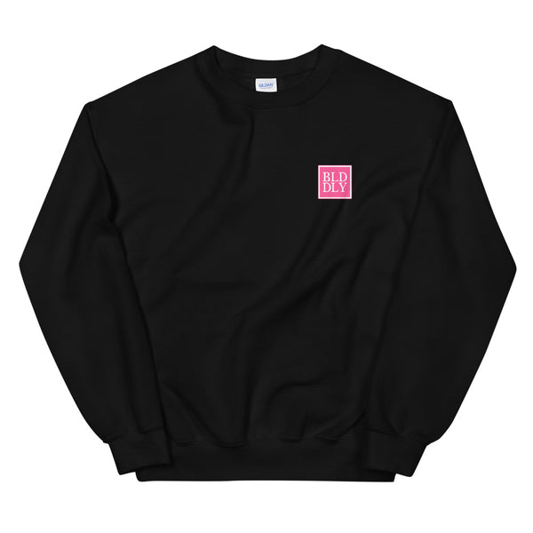 Black crewneck sweatshirt with pink and white build daily monogram logo