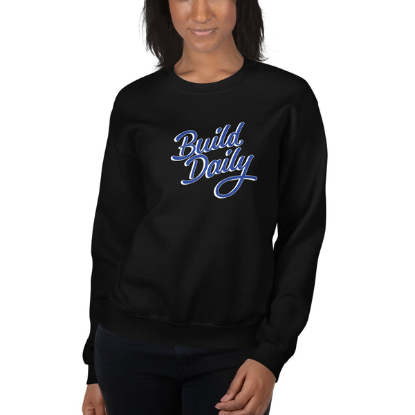 Woman wearing black crewneck sweatshirt with royal blue and white build daily signature logo